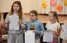 Trzy dziewczynki przedstawiające własnoręcznie napisane komiksy 