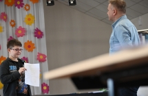 Mężczyzna i chłopiec. Chłopiec przedstawia narysowany własnoręcznie komiks 