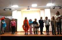 Kobieta oraz kilkanaścioro dzieci na scenie 