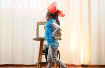 Dziewczynka z kokardą oraz boa z piór na scenie 