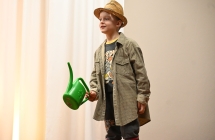 Chłopiec w kapeluszu trzymający konewkę 