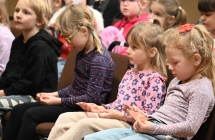 Dzieci siedzące na krzesełkach w trakcie improwizacji teatralnej 