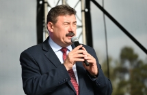 Mężczyzna w garniturze mówiący do mikrofonu ze sceny 