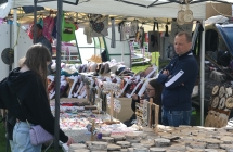 Stoisko z gadżetami za którym stoi mężczyzna 