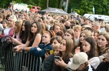 Kilkaset osób stojących przed sceną za barierkami 