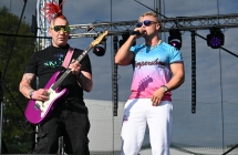 Dwoje mężczyzn na scenie. Jeden w charakterystycznej fryzurze - dredy stojące na głowie, drugi śpiewa do mikrofonu. 