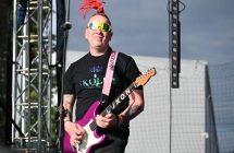 Mężczyzna ze stojącymi na głowie dredami na scenie - gra na gitarze 