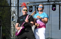 Dwoje mężczyzn na scenie. Jeden śpiewa do mikrofonu, drugi gra na gitarze 