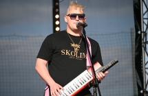 Mężczyzna grający na keyboardzie oraz śpiewający do mikrofonu 