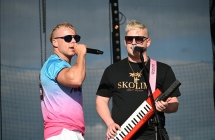 Dwoje mężczyzn na scenie. Obydwoje śpiewają do mikrofonów 