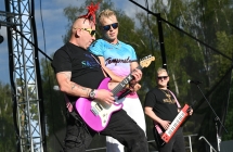 Troje mężczyzn na scenie. Jeden śpiewa, dwoje gra na instrumentach 