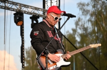 Gitarzysta w dżokejce i okularach przeciwsłonecznych 