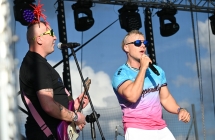 Dwoje muzyków na scenie. Jeden śpiewa do mikrofonu, drugi na gitarze 