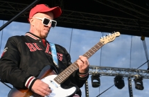 Gitarzysta w dżokejce i okularach przeciwsłonecznych 