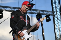 Gitarzysta w dżokejce i okularach przeciwsłonecznych 