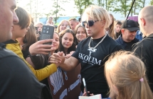 Artysta wykonujący zdjęcia i przybijający piątkę z fanami 