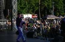 Młody piosenkarz na scenie. Przed sceną kilkadziesiąt osób 