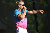 Artysta śpiewający na scenie do mikrofonu 