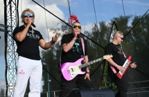 Troje artystów na scenie. Jeden śpiewa a dwoje grają na instrumentach 