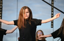 Dziewczynka w karbowanych włosach podczas tańczenia na scenie 