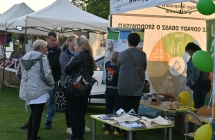 Stoisko z napisem - PGK oraz odwiedzający ją ludzie 