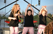 Trzy dziewczynki w trakcie tańczenia na scenie 