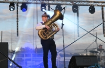 Mężczyzna w stroju ludowym grający na puzonie 