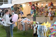 Dziewczynka z watą cukrową przy stoisku z gadżetami 