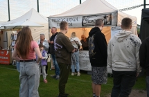 Kilka osób przy stoisku gastronomicznym 