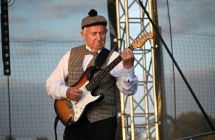 Mężczyzna w ludowym stroju grający na gitarze 