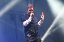 Mężczyzna w okularach śpiewający na scenie 