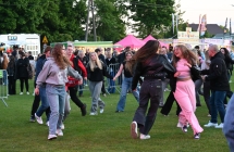 Kilkadziesiąt osób podczas tańca na placu imprezy masowej 