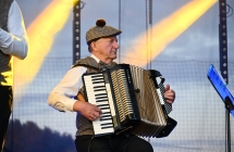 Mężczyzna grający na akordeonie w ludowym stroju 