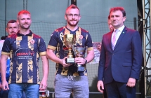 Czwórka mężczyzn - jeden w garniturze, troje w strojach piłkarskich 