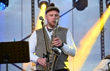 Mężczyzna w ludowym stroju grający na saksofonie 