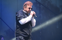 Mężczyzna śpiewający wieczorem do mikrofonu ze sceny 