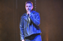 Młody mężczyzna podczas śpiewania piosenki na scenie 