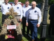 Czworo elegancko ubranych mężczyzn prezentujących wieniec dożynkowy 
