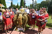 Sołectwo Żdżenice. Kobiety w jednakowych strojach z wieńcem dożynkowym 