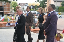 Kilka osób idących po chodniku do kościoła 