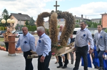 Mężczyźni niosący wieniec dożynkowy 
