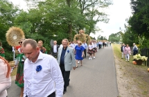 Kilkudziesięcioro ludzi w przemarszu dożynkowym 