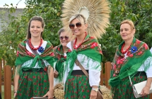 Cztery kobiety niosące wieniec dożynkowy 
