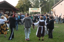 Kilkudziesięcioro uczestników dożynek tańczących w kółku 