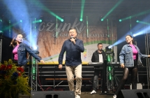 Wokalista wraz z klawiszowcem oraz dwiema tancerkami na scenie 