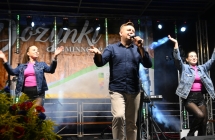 Piosenkarz wraz z dwiema tancerkami na scenie 