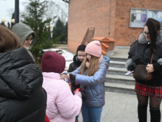Kilka osób stoi przed kościołem