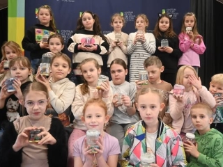 Zdjęcie grupowe kilkunastu dzieci z wykonanymi pracami