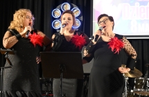 Trzy kobiety śpiewają do mikrofonów