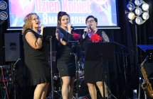 Trzy kobiety śpiewają do mikrofonów